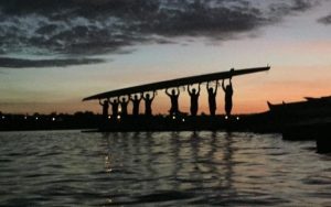 silhouette rowing eight held by 8 rowers in sunrise